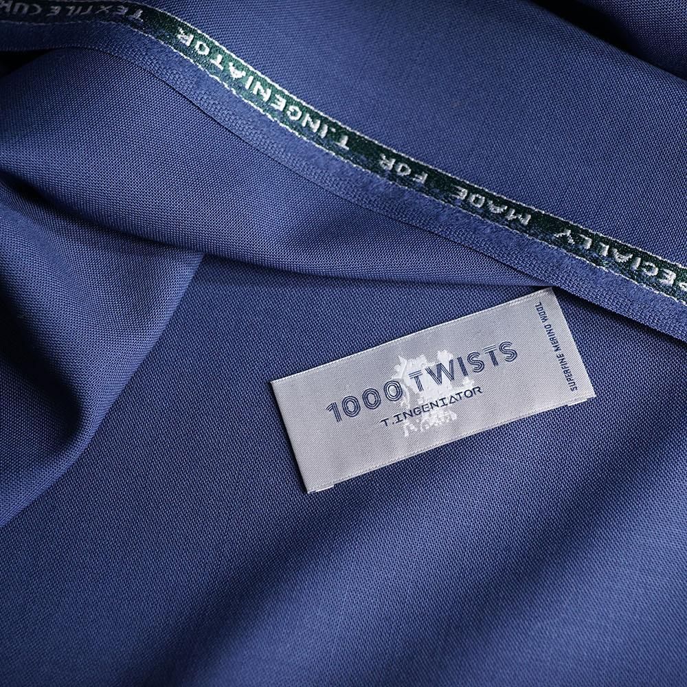 Blue fabric folded beside its woven edge and label